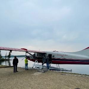 A red and white de Havilland Otter floatplane being loaded at the Leuenberger air base.
